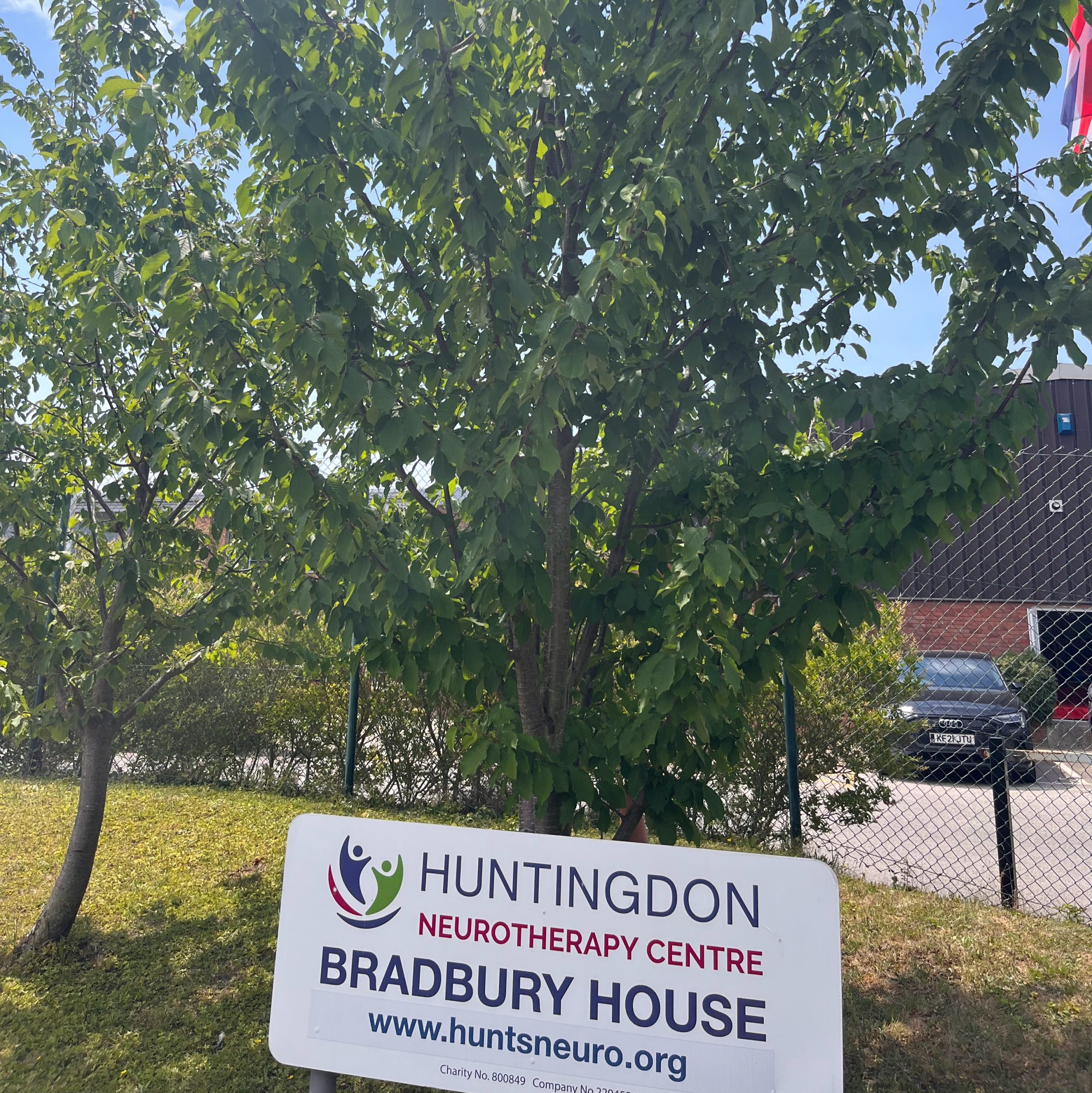 Huntingdon Neurotherapy Centre Bradbury House sign in front of cherry tree
